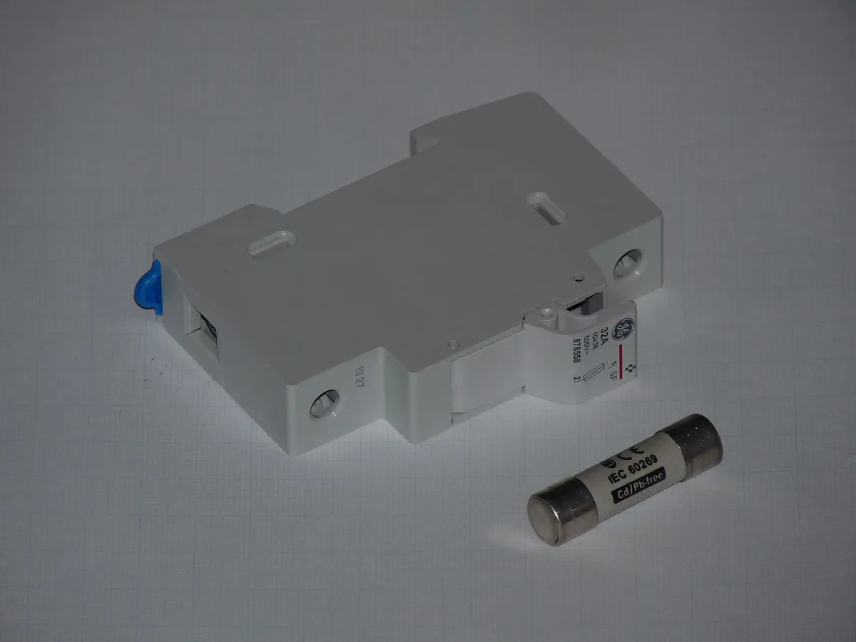 Rozłącznik bezpiecznikowy na szynę DIN obok cylindrycznej wkładki topikowej 10x38 mm z oznaczeniem IEC 60269