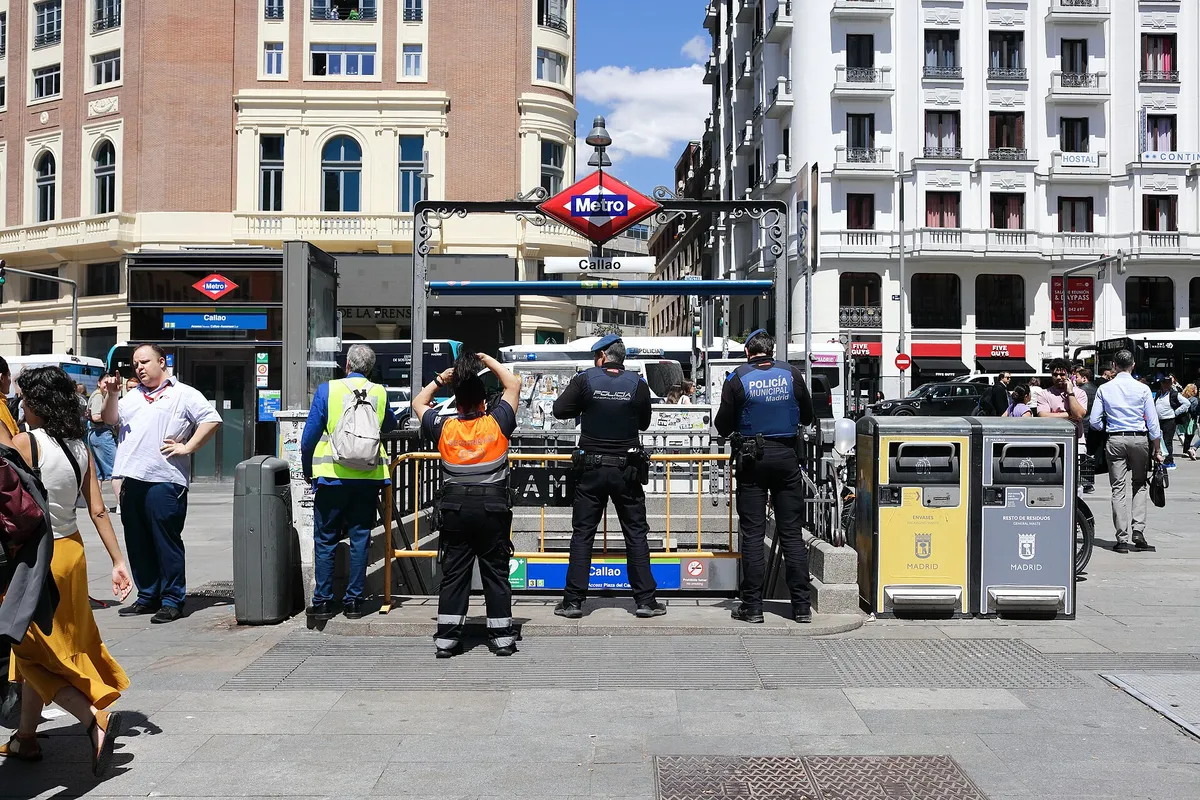 Zamknięte wejście do stacji metra w centrum Madrytu otoczone policją i przechodniami w słoneczny dzień 28 kwietnia 2025